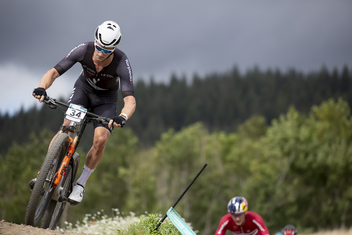 2023 UCI Cycling World Championships - Mountain Bike - Elite Men - Sam Gaze of New Zealand takes on a descent with a glowering sky behind