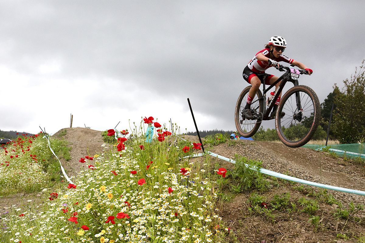 2023 UCI Cycling World Championships - Mountain Bike - Elite Women - Mona Mitterwallner of Austria gets some air next to wild flowers