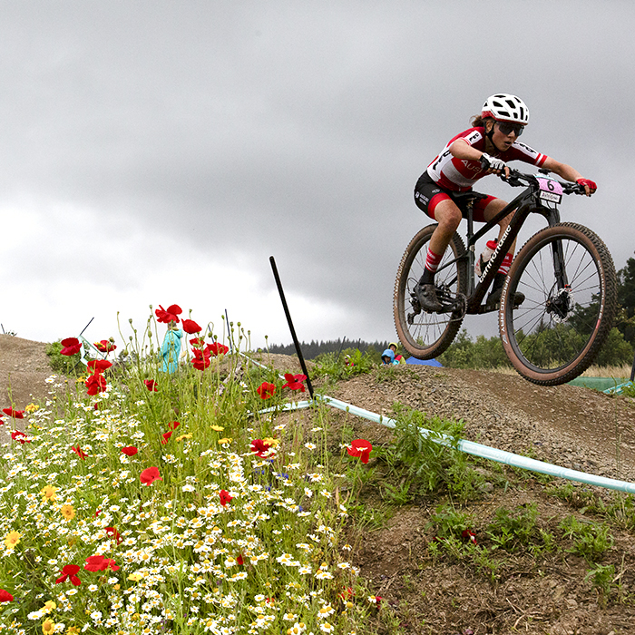 2023 UCI Cycling World Championships - Mountain Bike - Elite Women - Mona Mitterwallner of Austria gets some air next to wild flowers