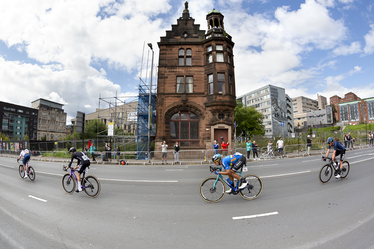 2023 UCI Cycling World Championships - Road Race - Elite Men - A group of riders pass the isolated Civic Rooms building