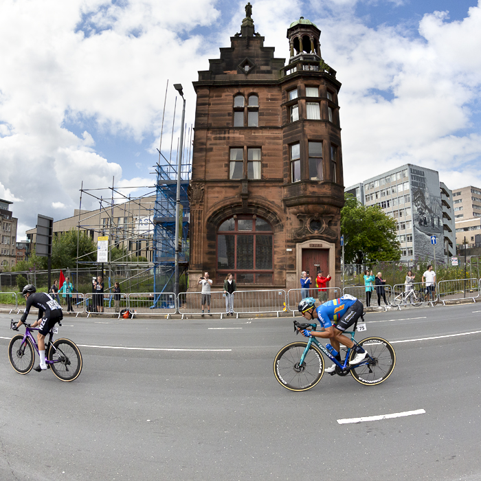 2023 UCI Cycling World Championships - Road Race - Elite Men - A group of riders pass the isolated Civic Rooms building