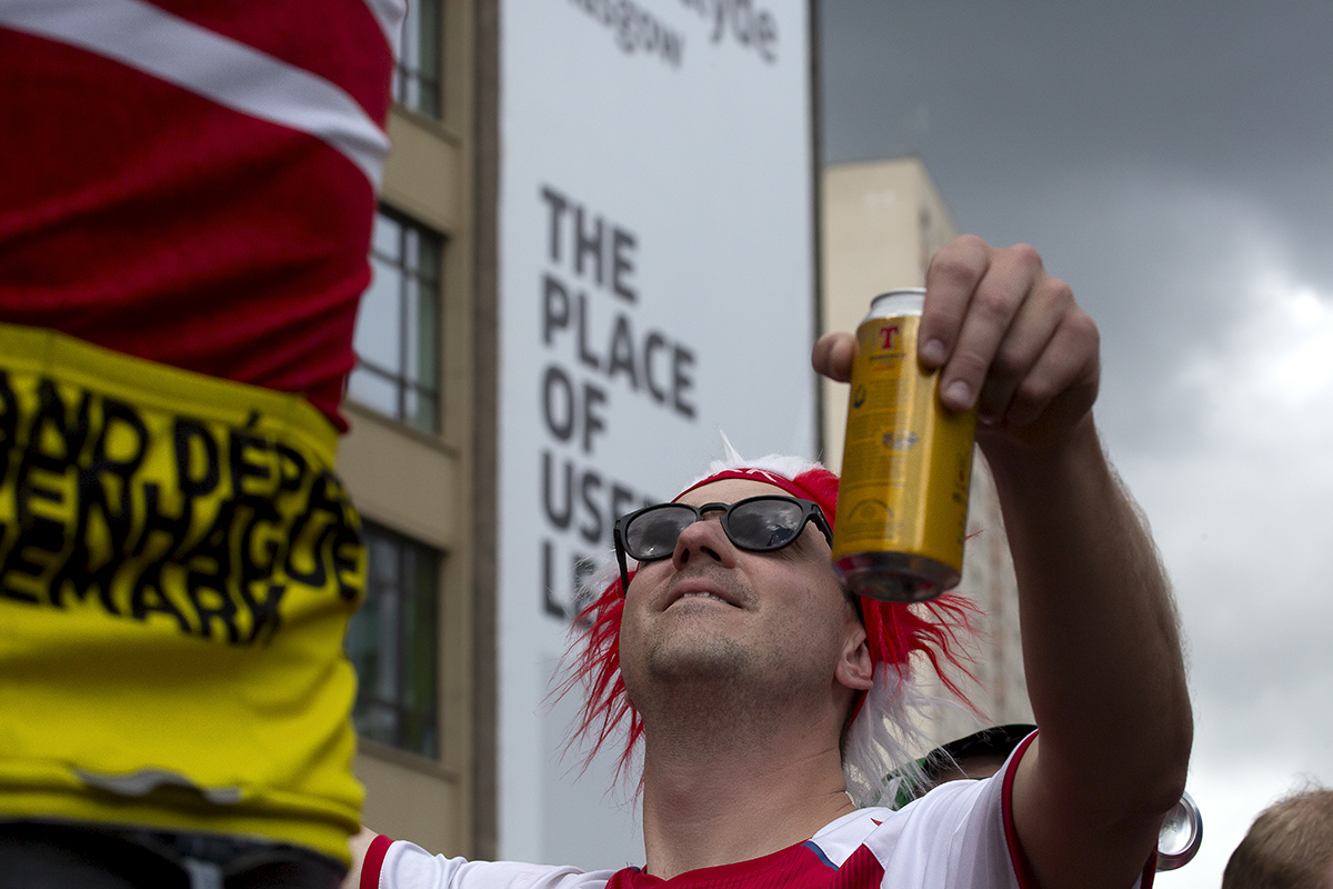 2023 UCI Cycling World Championships - Road Race - Elite Men - A Danish Fan wearing sunglasses holds a can of beer aloft as he looks up at the sky