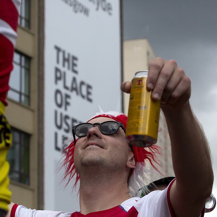 2023 UCI Cycling World Championships - Road Race - Elite Men - A Danish Fan wearing sunglasses holds a can of beer aloft as he looks up at the sky