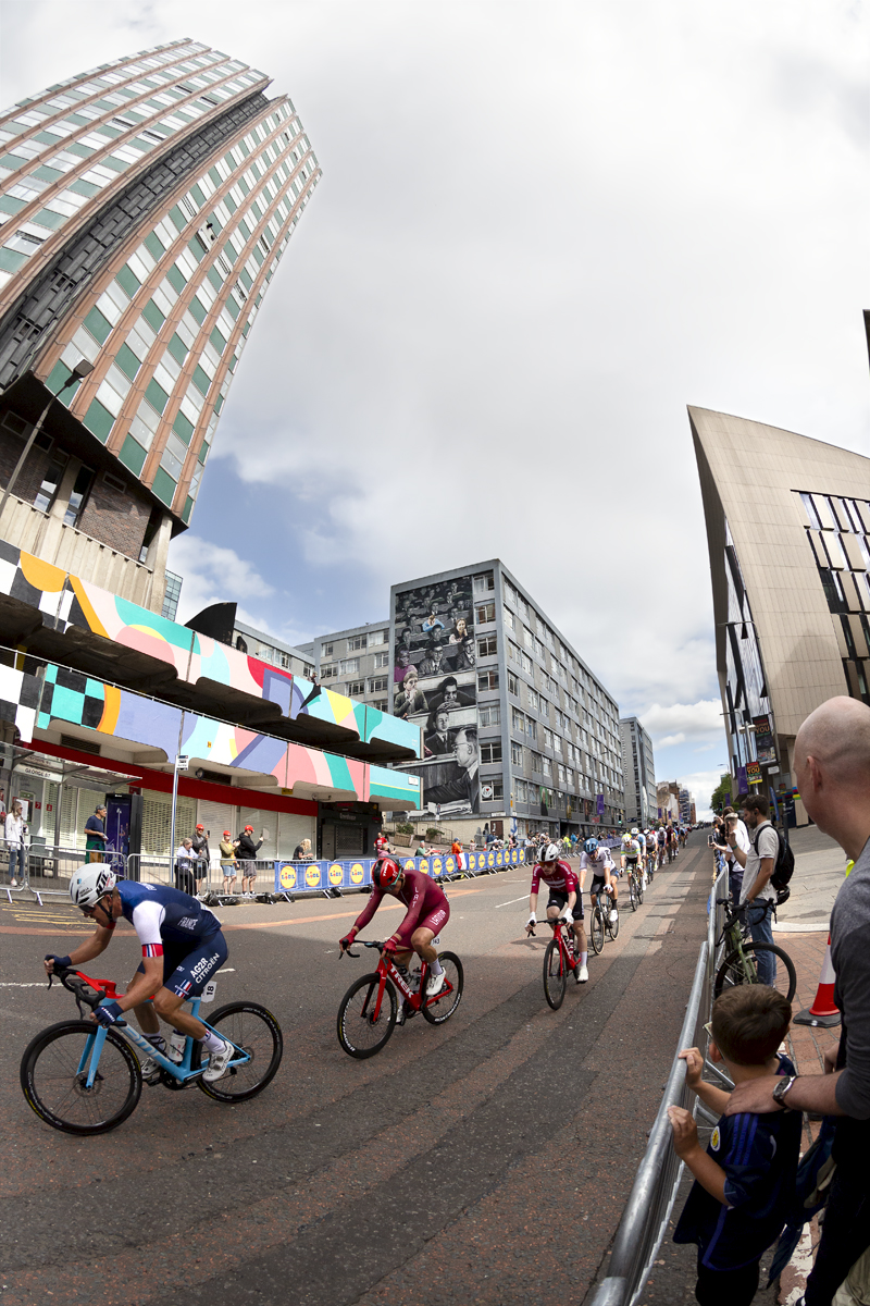 2023 UCI Cycling World Championships - Road Race - Elite Men - The race passes by the Livingstone Tower with one of the Glasgow murals in the background