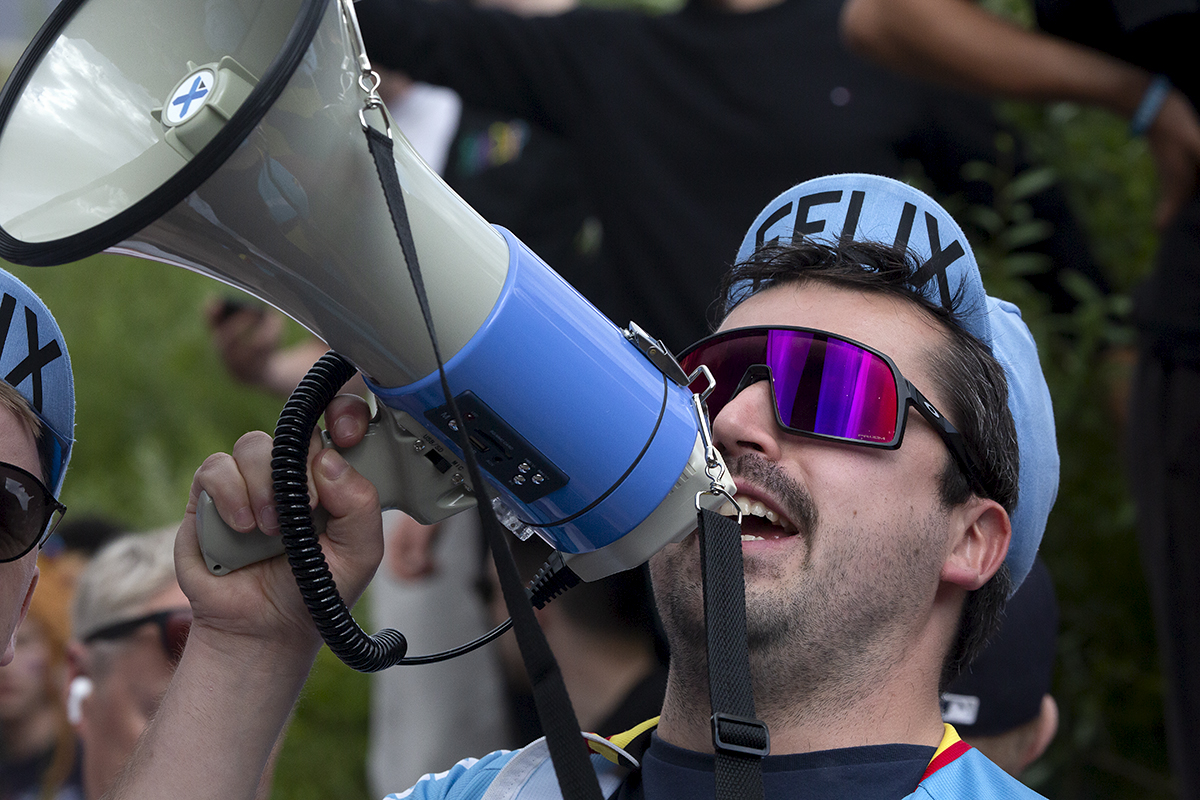 2023 UCI Cycling World Championships - Road Race - Elite Men - A Belgian fan in a Belgium cycling hat shouts through a megaphone at the side of the race