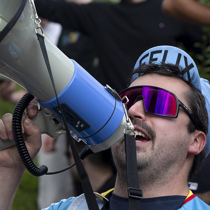 2023 UCI Cycling World Championships - Road Race - Elite Men - A Belgian fan in a Belgium cycling hat shouts through a megaphone at the side of the race