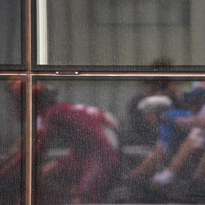 2023 UCI Cycling World Championships - Road Race - Elite Men - The race is reflected in the windows of an office block