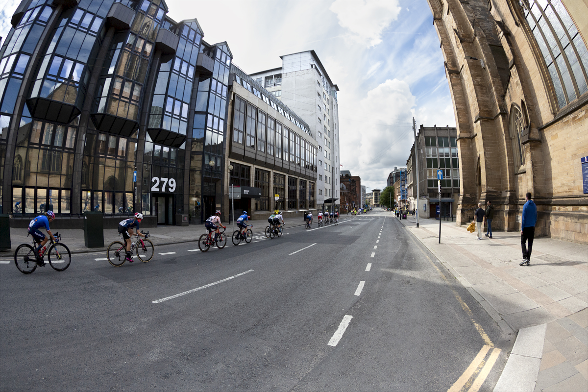 2023 UCI Cycling World Championships - Road Race - Elite Women - The peloton rides past glass fronted office buildings