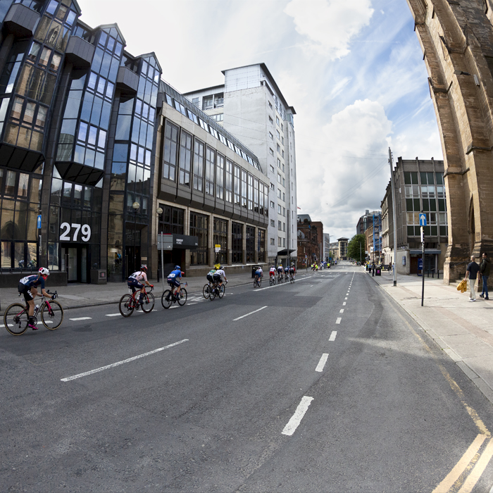 2023 UCI Cycling World Championships - Road Race - Elite Women - The peloton rides past glass fronted office buildings