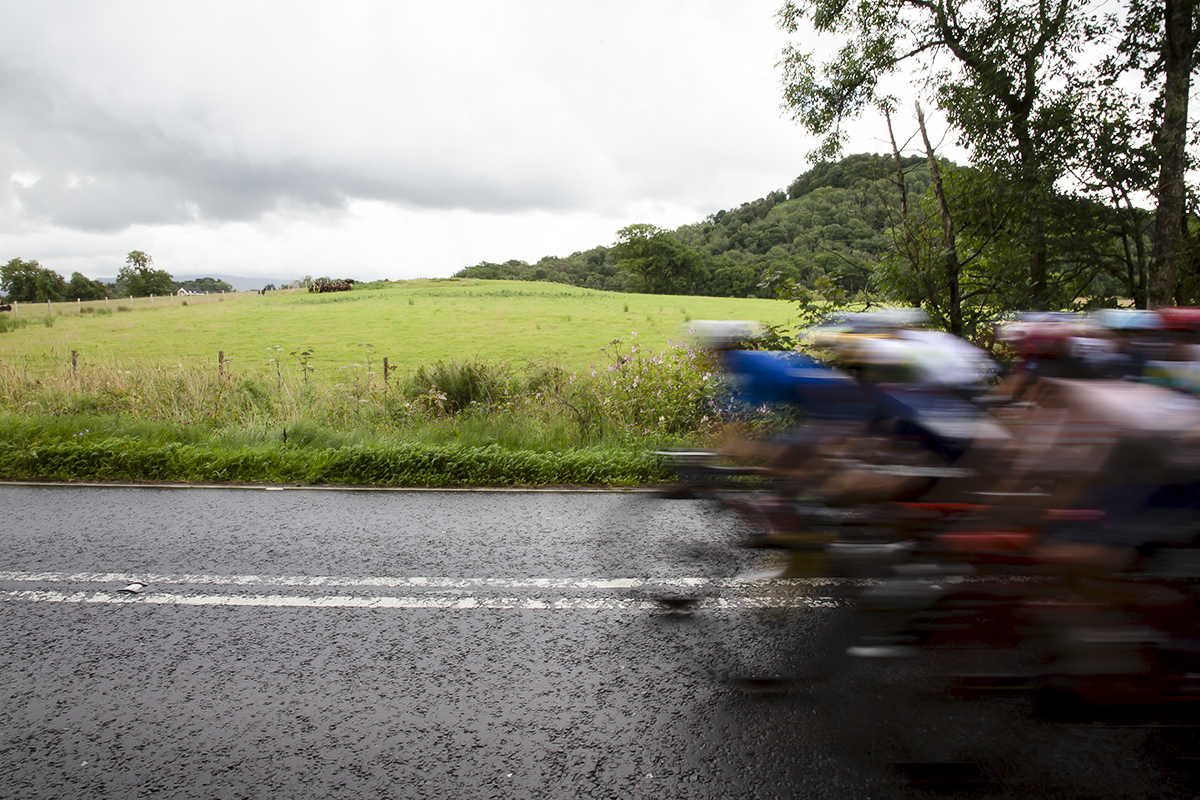 2023 UCI Cycling World Championships - Road Race - Elite Women - The peloton speed into shot with the countryside behind them