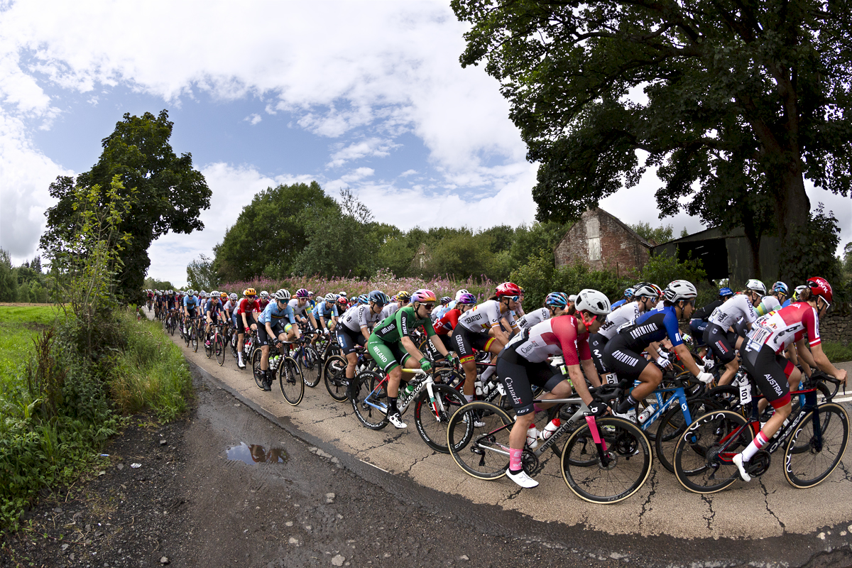 2023 UCI Cycling World Championships - Road Race - Elite Women - the peloton pass an old barn in the countryside