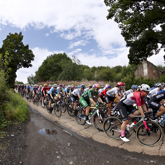 2023 UCI Cycling World Championships - Road Race - Elite Women - the peloton pass an old barn in the countryside