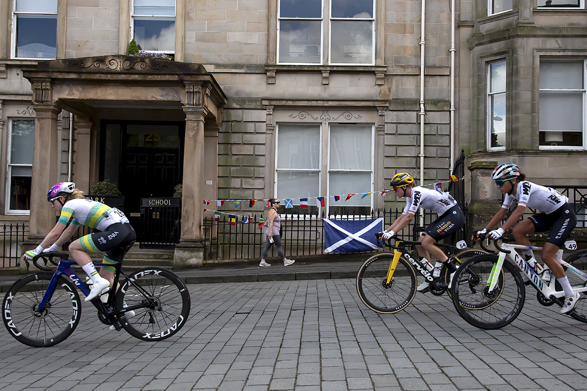 2023 UCI Cycling World Championships - Road Race - Elite Women - The race passes grand stone buildings with bunting and a Scottish flag in the background