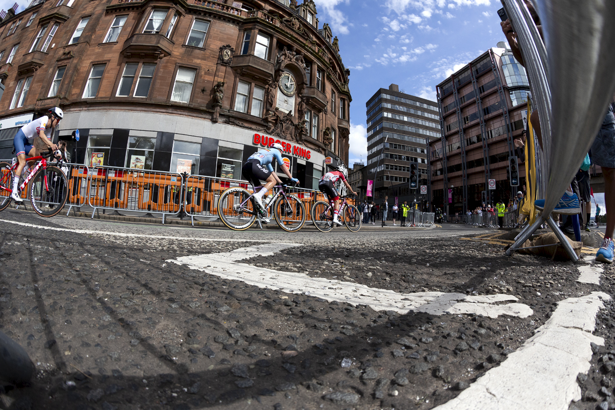 2023 UCI Cycling World Championships - Road Race - Elite Women - The riders pass a curved red, ornate sandstone building