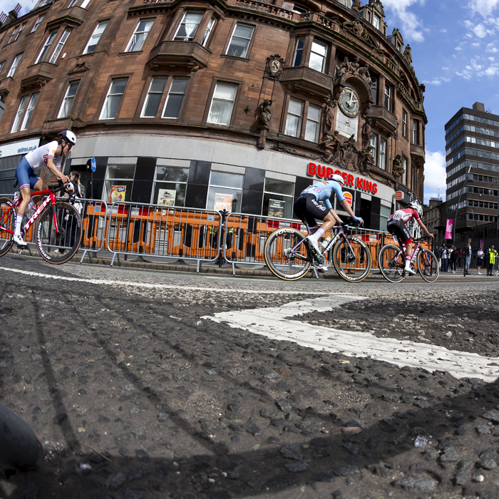 2023 UCI Cycling World Championships - Road Race - Elite Women - The riders pass a curved red, ornate sandstone building