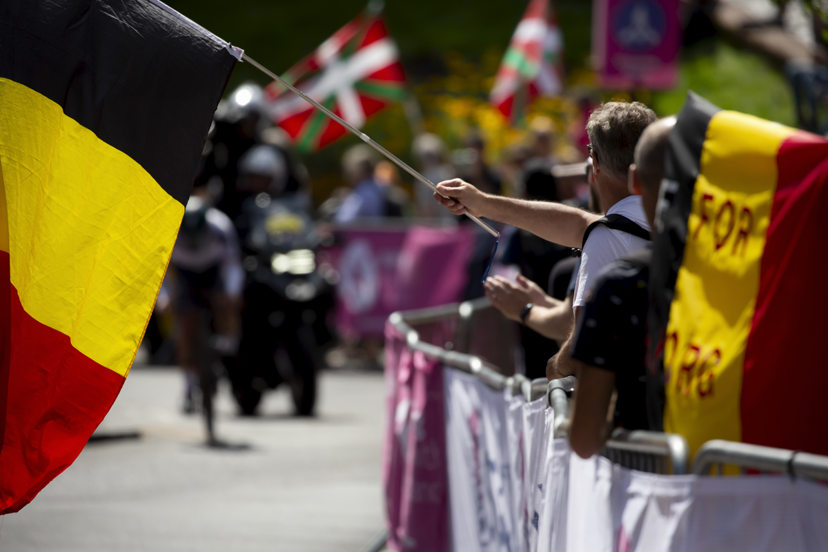 2023 UCI Cycling World Championships - Time Trial - Elite Men - A Belgian flag is lowered onto the course in front of an approaching rider