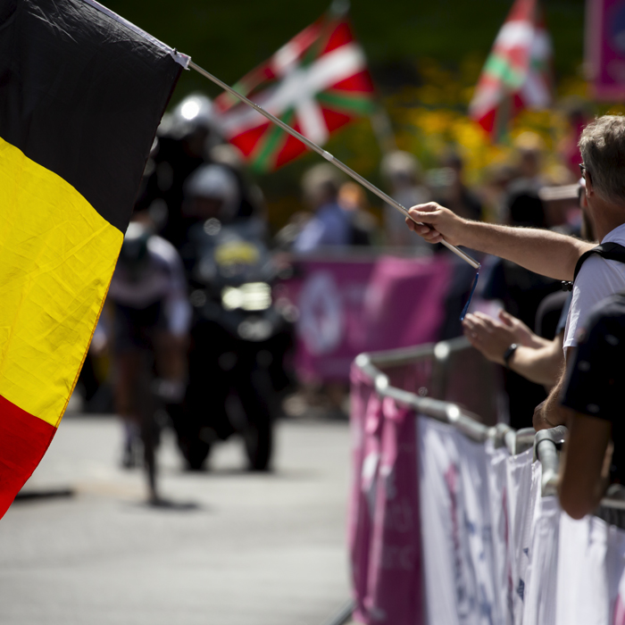 2023 UCI Cycling World Championships - Time Trial - Elite Men - A Belgian flag is lowered onto the course in front of an approaching rider