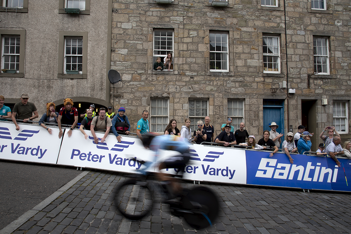 2023 UCI Cycling World Championships - Time Trial - Elite Women - One of the Belgian riders speeds past fans cheering from the side of the road and hanging out of the windows of nearby buildings