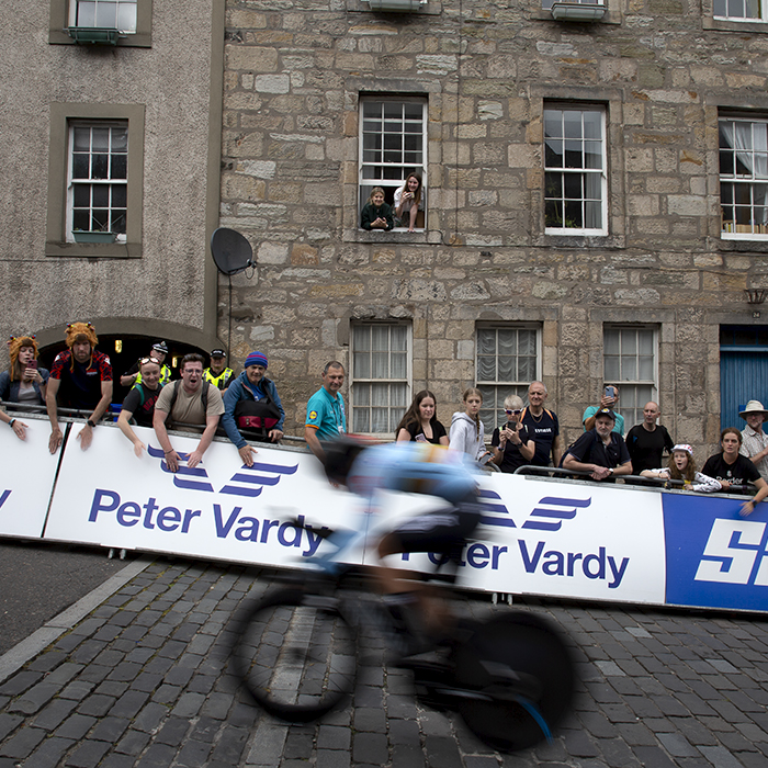 2023 UCI Cycling World Championships - Time Trial - Elite Women - One of the Belgian riders speeds past fans cheering from the side of the road and hanging out of the windows of nearby buildings