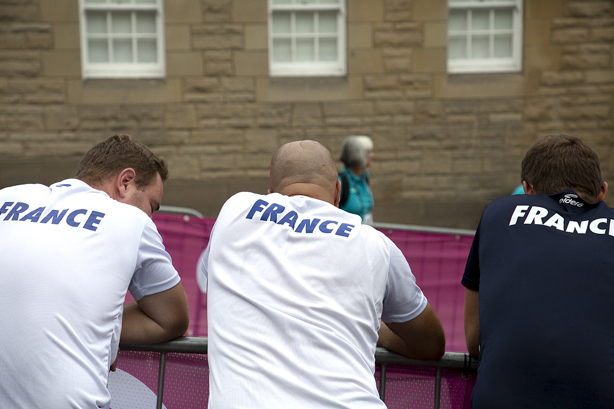 2023 UCI Cycling World Championships - Time Trial - Elite Women - Team France support staff lean on the barriers as they await the arrival of one of their riders