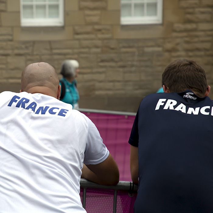 2023 UCI Cycling World Championships - Time Trial - Elite Women - Team France support staff lean on the barriers as they await the arrival of one of their riders