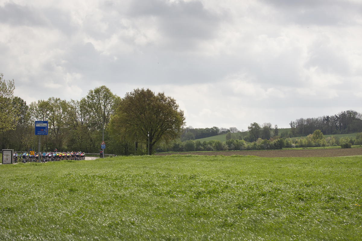 Amstel Gold Race 2024 - The riders across a grassy field and ope countryside near Voerendaal