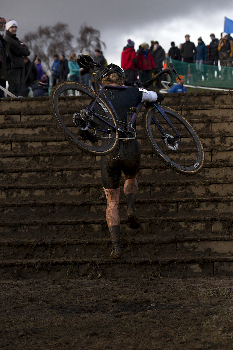 British National Cyclo-Cross Championships 2023 - Annie Last carries her bike on her shoulder up the steps