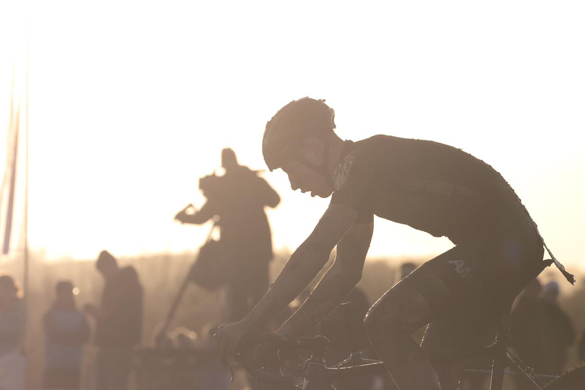 British National Cyclo-Cross Championships 2023 - Bjoern Koerdt is lit from behind by the sun as he passes the TV camera stand