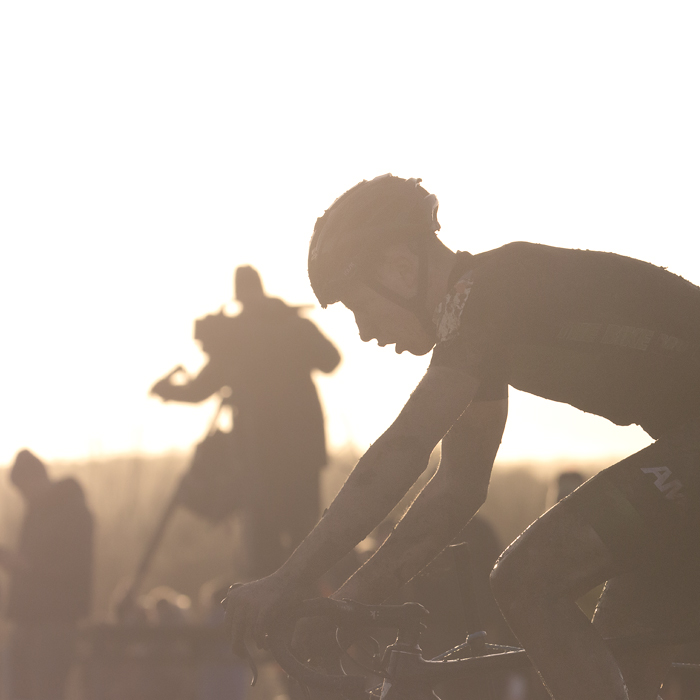 British National Cyclo-Cross Championships 2023 - Bjoern Koerdt is lit from behind by the sun as he passes the TV camera stand