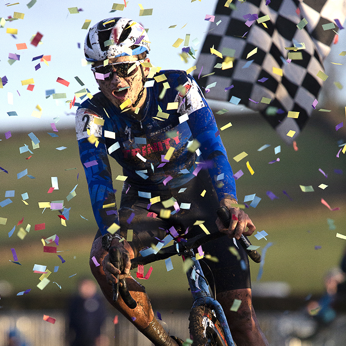 British National Cyclo-Cross Championships 2023 - Cameron Mason rides through confetti on the finish line with the chequered flag in the background