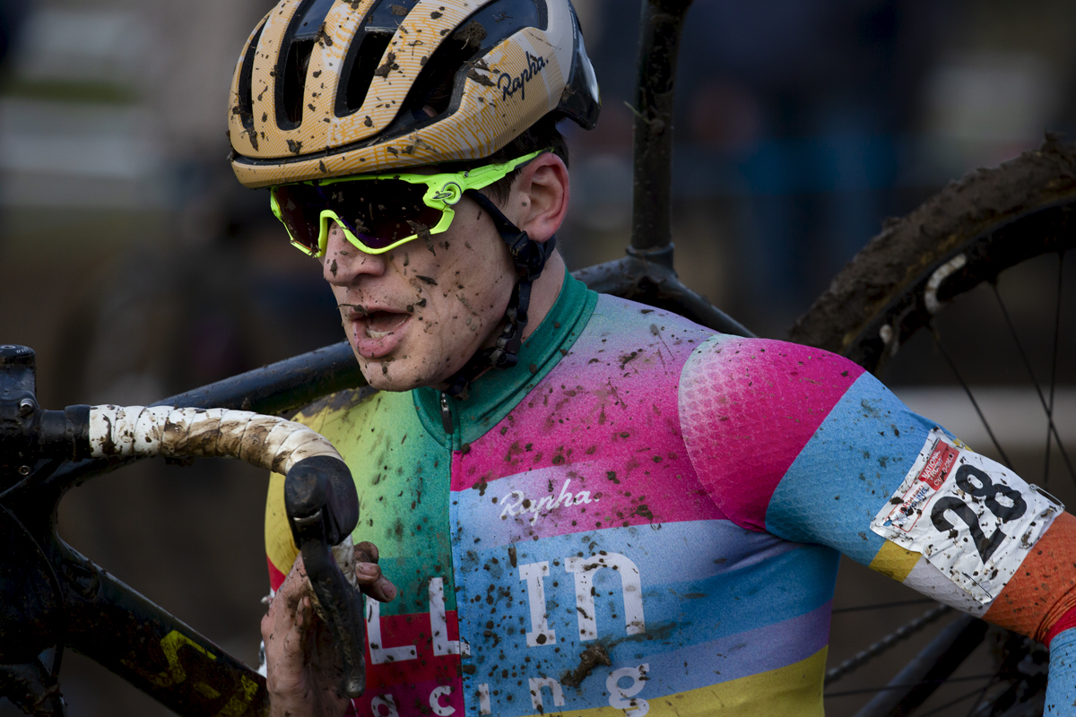 British National Cyclo-Cross Championships 2023 - Joshua Jones runs with his bike on his shoulder, his face and shirt splashed with mud