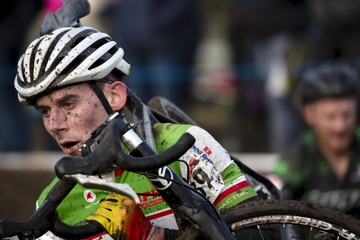 British National Cyclo-Cross Championships 2023 - Neil Scott holds onto his handlebars as he carries his bike through a muddy section