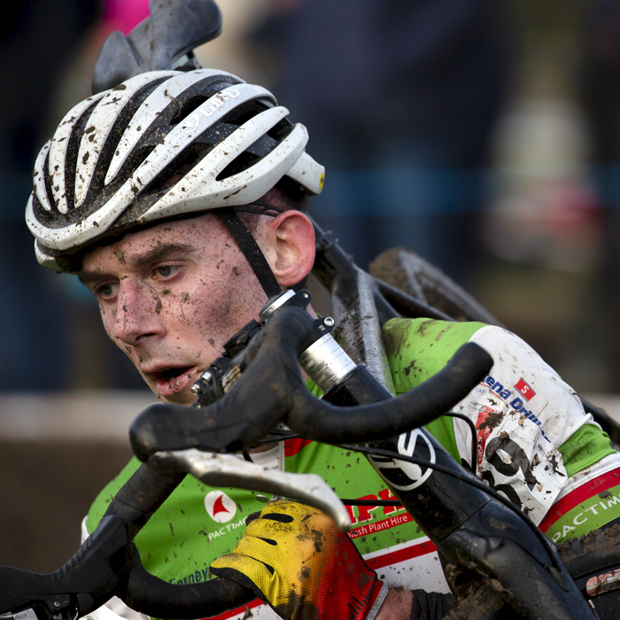 British National Cyclo-Cross Championships 2023 - Neil Scott holds onto his handlebars as he carries his bike through a muddy section