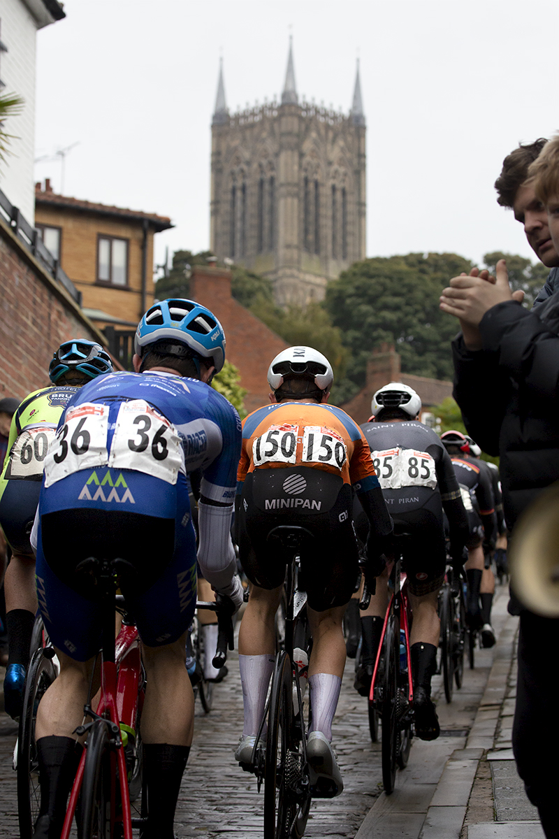 British National Road Championships 2021 - Men’s Road Race - Rear view of the peloton with Lincoln Cathedral in the background