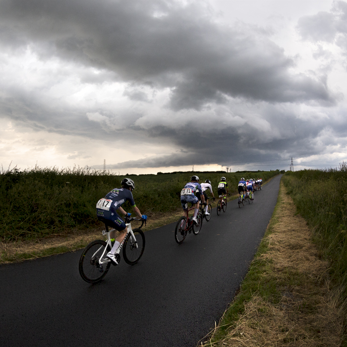 British National Road Championships 2023 - Men’s Road Race - The last riders pass by near Brotton under stormy skies