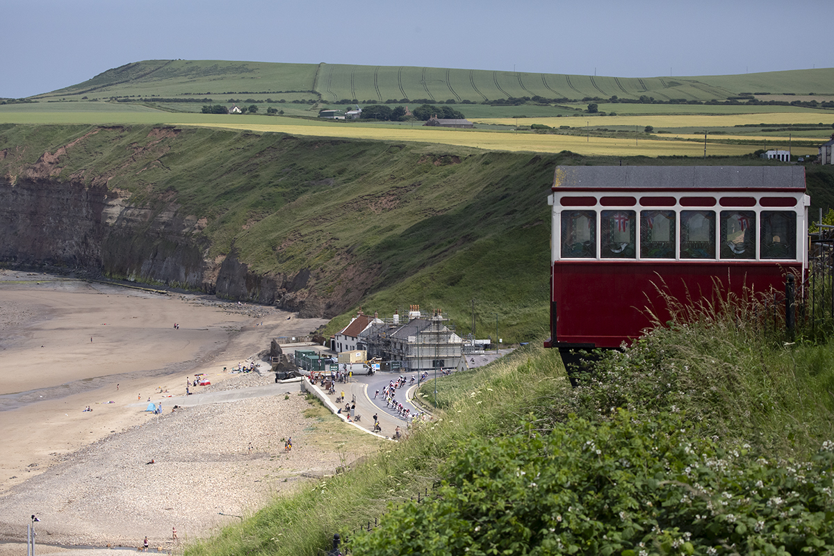 British National Road Championships 2023 - Men’s Road Race - The race on the sea front from a distance with the funicular railway in the foreground