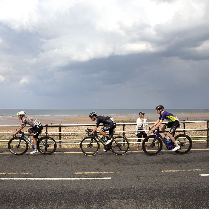 British National Road Championships 2023 - Men’s Road Race - Riders race down the seafront cheered on by a female fan