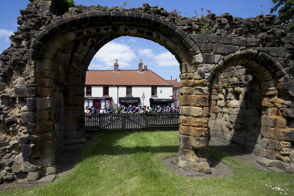 British National Road Championships 2024 - Men’s Road Race -The race is seen through an arch of Guisborough Priory as it passes through the town