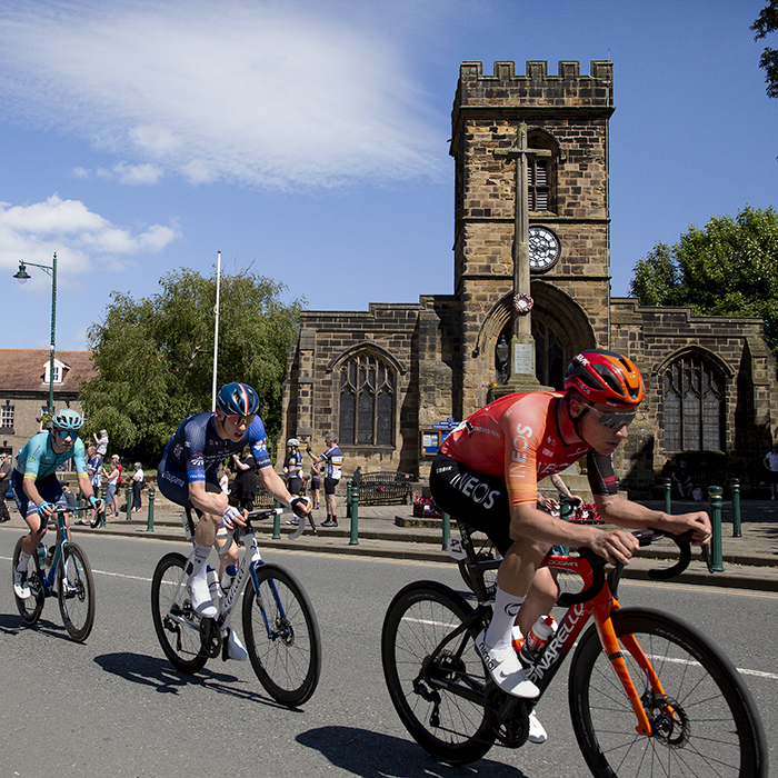 British National Road Championships 2024 - Men’s Road Race - The peloton passes by St Nicholas Church and war memorial in Guisborough