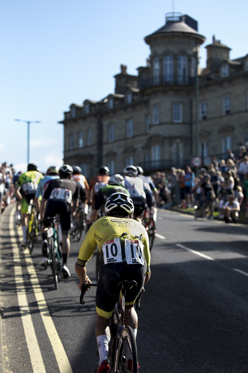 British National Road Championships 2024 - Men’s Road Race - Max Stedman follows a group of riders up the climb with a grand stone building to one side