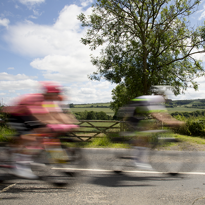 British National Road Championships 2024 - Men’s Road Race - The peloton speeds past a five bar gate and open countryside in Upleatham