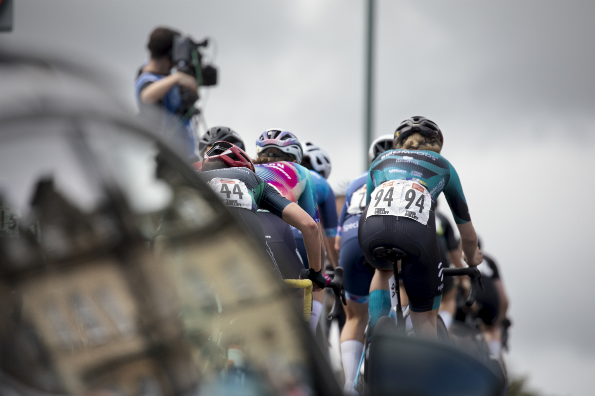 British National Road Championships 2024 - Women’s Road Race - Henrietta Colborne of Roompods from behind as she climbs the hill at Saltburn with a team car in the foreground