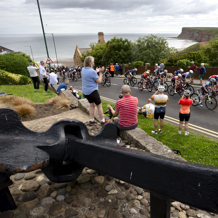 British National Road Championships 2024 - Women’s Road Race - A large ship’s anchor in the foreground as fans cheer the riders up the climb at Saltburn-by-the-Sea