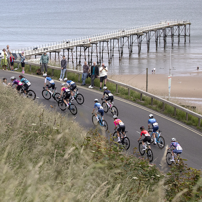 British National Road Championships 2024 - Women’s Road Race - Riders climbs the hill at Saltburn with the pier and beach in the background