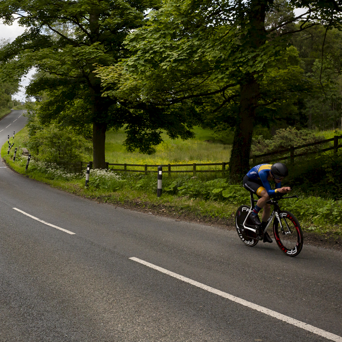 British National Road Championships 2024 - Men’s U23 Time Trial - Harry Codd rides down a road lined by mature trees