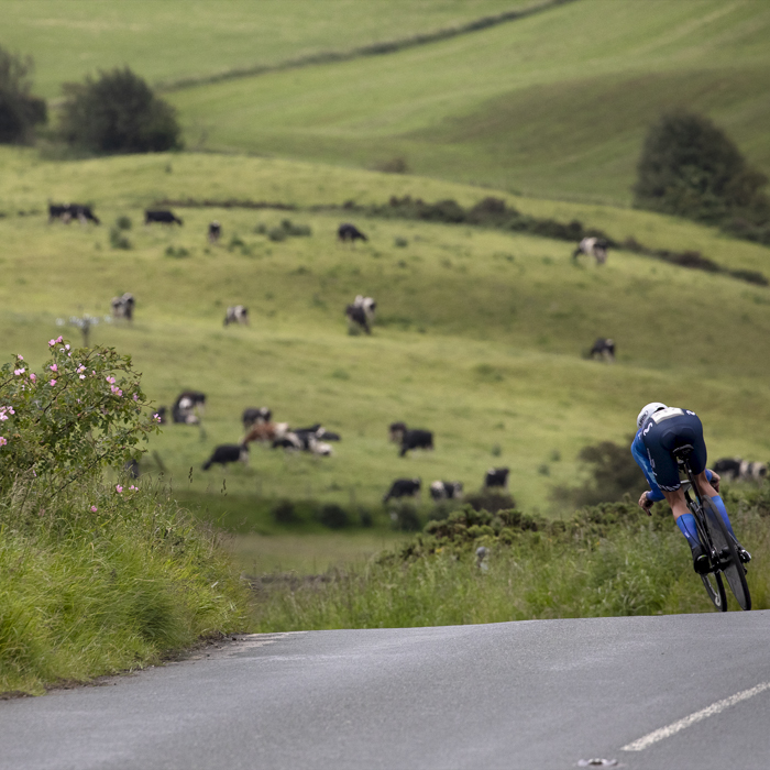 British National Road Championships 2024 -  Women’s Time Trial - Claire Steels takes a descent with a field of cows in the distance and roses in the hedgerow
