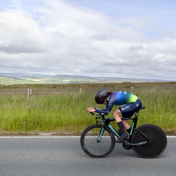 British National Road Championships 2024 -  Women’s Time Trial -Tamsin Miller in an aero tuck passes through countryside lit by the summer sun