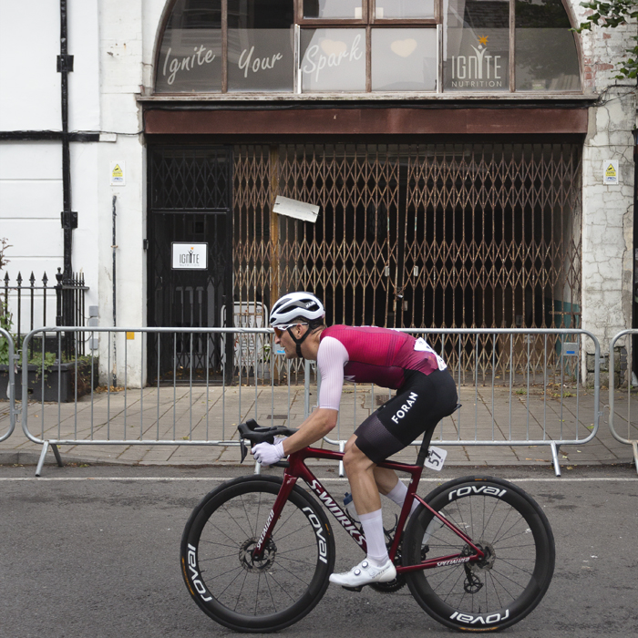 British National Road Championships 2025 - Road Race - Men - Danylo Riwnyj of Foran CT races past a building with an archway