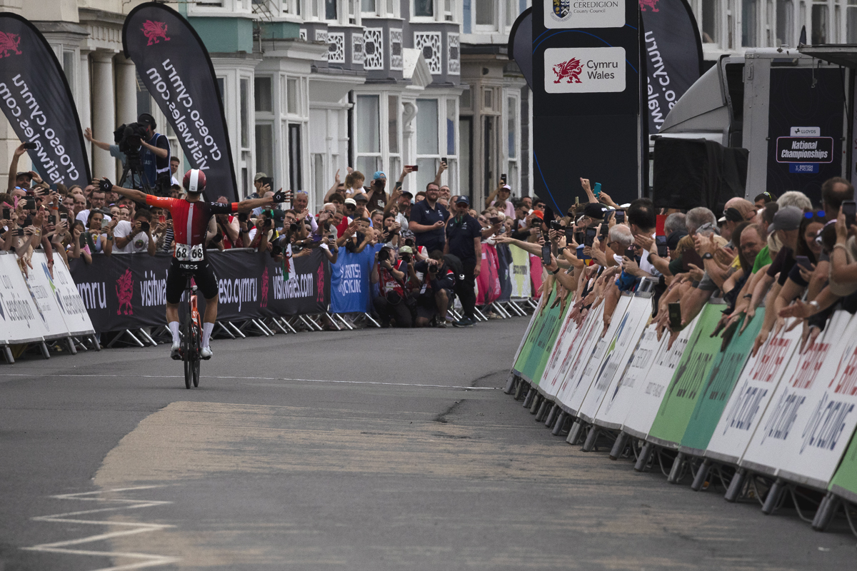 British National Road Championships 2025 - Road Race - Men - Sam Watson of Ineos Grenadiers raises his arms as he is seen from the rear winning the race