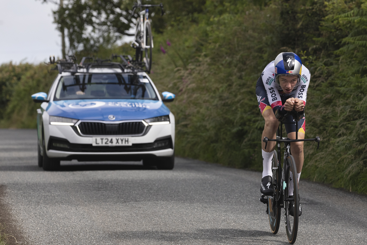British National Road Championships 2025 - Time Trial - U23 Men - Callum Thornley of Red Bull - BORA - hansgrohe Rookies followed by a team car as he rides on small country roads